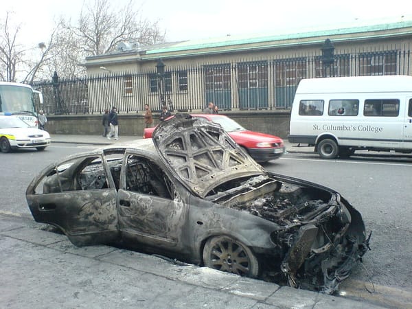 A burnt out car from the last time Dublin had a riot, over the Love Ulster march